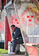 19 May 2025; Drogheda United manager Kevin Doherty sits in the away dugout before the SSE Airtricity Men's Premier Division match between Shelbourne and Drogheda United at Tolka Park in Dublin. Photo by Sam Barnes/Sportsfile