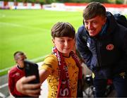 23 May 2025; Chris Forrester of St Patrick's Athletic takes a selfie with young St Patrick's Athletic supporter Baleigh Kelly, age 12, before the SSE Airtricity Men's Premier Division match between St Patrick's Athletic and Waterford at Richmond Park in Dublin. Photo by Seb Daly/Sportsfile