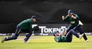 25 May 2025; Ireland captain Paul Stirling, right, celebrates as teammate Andrew Balbirnie, centre, takes the wicket of West Indies batter Evin Lewis during match three of the One Day International Series between Ireland and the West Indies at Castle Avenue Cricket Ground in Dublin. Photo by Seb Daly/Sportsfile