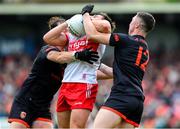 24 May 2025; Conor Doherty of Derry is taackled by Barry McCambridge and Oisin Conaty of Armagh, 12, during the GAA Football All-Ireland Senior Championship Round 1 match between Armagh and Derry at the BOX-IT Athletic Grounds in Armagh. Photo by Ray McManus/Sportsfile
