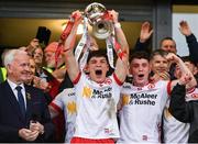 28 May 2025; Tyrone captain Joey Clarke, centre, lifts the trophy, presented by Ulster Council Chairman Michael Geoghegan, left, after his side's victory in the Dalata Hotel Group GAA Football All-Ireland U20 Championship final match between Louth and Tyrone at BOX-IT Athletic Grounds in Armagh. Photo by Oliver McVeigh/Sportsfile
