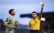 30 May 2025; Referee Rob Hennessy shows a yellow card to Ronan Boyce of Derry City, left,during the SSE Airtricity Men's Premier Division match between Bohemians and Derry City at Dalymount Park in Dublin. Photo by Seb Daly/Sportsfile