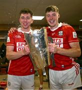 7 June 2025; Cork players Ethan Twomey, left, and Eoin Downey celebrate with the Mick Mackey Cup in the dressing room after their side's victory in the Munster GAA Hurling Senior Championship final match between Limerick and Cork at TUS Gaelic Grounds in Limerick. Photo by Piaras Ó Mídheach/Sportsfile