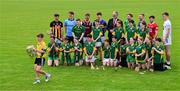10 June 2025; Michael Grogan, from Scoil Mhuire agus Chormaic  in Kilcorma, jokingly runs away with the Liam MacCarthy Cup during a group photo with Uachtarán Chumann Lúthchleas Gael Jarlath Burns, hurlers, from left, Billy Ryan of Kilkenny, Darragh Gray of Dublin, Fintan Burke of Galway, Jake Morris of Tipperary, Cian Lynch of Limerick, Podge Delaney of Laois, Niall O'Leary of Cork and Paul Dolan of Kildare and pupils from his own school at the national launch of the GAA Hurling All-Ireland Senior Championship Series at the Faithful Fields in Kilcormac, Offaly. Photo by Brendan Moran/Sportsfile