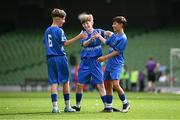 11 June 2025; Jamie Walsh of Lusk SNS, Dublin, right, celebrates with teammates Harry Gleeson and Dylan Maguire after scoring a goal during the FAI Primary 5s Finals Day at the Aviva Stadium in Dublin. Photo by Seb Daly/Sportsfile