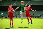 11 June 2025; Kyle Cormican of Scoil Íosa, Oranmore, Galway, in action against Ned MacSweeney and Harry Randles of Scoil Niocláis, Corcaigh, during the FAI Primary 5s Finals Day at the Aviva Stadium in Dublin. Photo by Seb Daly/Sportsfile