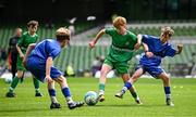 11 June 2025; Kyle Cormican of Scoil Íosa, Oranmore, Galway, in action against Harry Gleeson and Patryk Jachymczak of Lusk SNS, Dublin, during the FAI Primary 5s Finals Day at the Aviva Stadium in Dublin. Photo by Seb Daly/Sportsfile