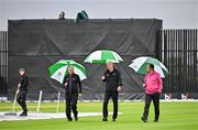 14 June 2025; Umpires, from left, Mark Hawthorne, Aidan Seaver and Johnny Kennedy inspect the pitch before abandoning match two of the T20 International Series between Ireland and the West Indies at Bready Cricket Club in Magheramason, Tyrone. Photo by Sam Barnes/Sportsfile