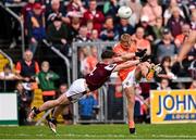 14 June 2025; Cian McConville of Armagh kicks a two-point score despite the tackle of Jack Glynn of Galway during the GAA Football All-Ireland Senior Championship Round 3 match between Galway and Armagh at Kingspan Breffni in Cavan. Photo by Ben McShane/Sportsfile