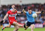14 June 2025; Niall Toner of Derry kicks a point despite the efforts of John Small of Dublin during the GAA Football All-Ireland Senior Championship Round 3 match between Dublin and Derry at Páirc Esler in Newry, Down. Photo by Thomas Flinkow/Sportsfile