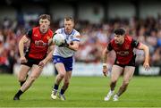 15 June 2025; Ryan McAnespie of Monaghan in action against Down players, from left, Odhran Murdock and James Guinness during the GAA Football All-Ireland Senior Championship Round 3 match between Monaghan and Down at BOX-IT Athletic Grounds in Armagh. Photo by Thomas Flinkow/Sportsfile