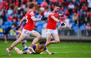 15 June 2025; Ciaran Downey of Louth shoots to score his side's second goal despite the efforts of Cillian Rouine of Clare during the GAA Football All-Ireland Senior Championship Round 3 match between Louth and Clare at Laois Hire O'Moore Park in Portlaoise, Laois. Photo by Shauna Clinton/Sportsfile