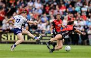15 June 2025; Mícheál Bannigan of Monaghan on his way to scoring his side's first goal despite the efforts of Pierce Laverty of Down during the GAA Football All-Ireland Senior Championship Round 3 match between Monaghan and Down at BOX-IT Athletic Grounds in Armagh. Photo by Thomas Flinkow/Sportsfile