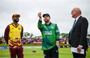 15 June 2025; Ireland captain Paul Stirling performs the toss in the company of West Indies captain Shai Hope and match referee Jeff Crowe match three of the T20 International Series between Ireland and the West Indies at Bready Cricket Club in Magheramason, Tyrone. Photo by Ramsey Cardy/Sportsfile