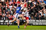15 June 2025; Mattie Donnelly of Tyrone kicks a point despite pressure from Gerard Smith, behind, and Oisin Kiernan of Cavan during the GAA Football All-Ireland Senior Championship Round 3 match between Tyrone and Cavan at Brewster Park in Enniskillen, Fermanagh. Photo by Ben McShane/Sportsfile