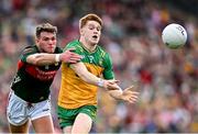 15 June 2025; Ciaran Moore of Donegal in action against Jordan Flynn of Mayo during the GAA Football All-Ireland Senior Championship Round 3 match between Donegal and Mayo at King & Moffatt Dr Hyde Park in Roscommon. Photo by Seb Daly/Sportsfile