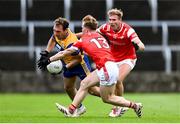 15 June 2025; Alan Sweeney of Clare is tackled by Louth players Ciaran Keenan, left, and Conor Grimes during the GAA Football All-Ireland Senior Championship Round 3 match between Louth and Clare at Laois Hire O'Moore Park in Portlaoise, Laois. Photo by Shauna Clinton/Sportsfile