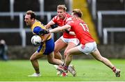 15 June 2025; Alan Sweeney of Clare is tackled by Louth players Conor Grimes, left, and Ciaran Keenan during the GAA Football All-Ireland Senior Championship Round 3 match between Louth and Clare at Laois Hire O'Moore Park in Portlaoise, Laois. Photo by Shauna Clinton/Sportsfile