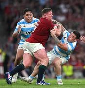 20 June 2025; Tadhg Furlong of British & Irish Lions is tackled by Argentina players Boris Wenger, left, and Francisco Coria Marchetti during the Lions 1888 Cup match between the British & Irish Lions and Argentina at the Aviva Stadium in Dublin. Photo by Brendan Moran/Sportsfile