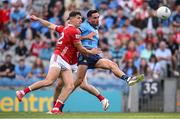 21 June 2025; Niall Scully of Dublin kicks a point under pressure from Sean McDonnell of Cork during the GAA Football All-Ireland Senior Championship preliminary quarter-final match between Dublin and Cork at Croke Park in Dublin. Photo by Ramsey Cardy/Sportsfile