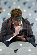 7 August 2004; A Mayo fan reads his match programme while eating an ice cream. Bank of Ireland All-Ireland Senior Football Championship Quarter Final, Mayo v Tyrone, Croke Park, Dublin. Picture credit; Brendan Moran / SPORTSFILE