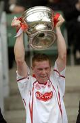 26 September 2004; Marc Cunningham, Tyrone, lifts the Cup. All-Ireland Minor Football Championship Final, Kerry v Tyrone, Croke Park, Dublin. Picture credit; Ray McManus / SPORTSFILE *** Local Caption *** Any photograph taken by SPORTSFILE during, or in connection with, the 2004 All-Ireland Minor Football Final which displays GAA logos or contains an image or part of an image of any GAA intellectual property, or, which contains images of a GAA player/players in their playing uniforms, may only be used for editorial and non-advertising purposes.  Use of photographs for advertising, as posters or for purchase separately is strictly prohibited unless prior written approval has been obtained from the Gaelic Athletic Association.