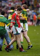 26 September 2004; Peadar Gardnier, Mayo, leaves the field as Kerry players celebrate. Bank of Ireland All-Ireland Senior Football Championship Final, Kerry v Mayo, Croke Park, Dublin. Picture credit; Ray McManus / SPORTSFILE *** Local Caption *** Any photograph taken by SPORTSFILE during, or in connection with, the 2004 Bank of Ireland All-Ireland Senior Football Final which displays GAA logos or contains an image or part of an image of any GAA intellectual property, or, which contains images of a GAA player/players in their playing uniforms, may only be used for editorial and non-advertising purposes.  Use of photographs for advertising, as posters or for purchase separately is strictly prohibited unless prior written approval has been obtained from the Gaelic Athletic Association.