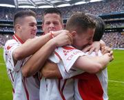 26 September 2004; Tyrone players, from left, Niall Kerr, Shane O'Hagan and Gareth Devlin celebrate with manager Liam Doyle after victory in the final. All-Ireland Minor Football Championship Final, Kerry v Tyrone, Croke Park, Dublin. Picture credit; Brian Lawless / SPORTSFILE *** Local Caption *** Any photograph taken by SPORTSFILE during, or in connection with, the 2004 All-Ireland Minor Football Final which displays GAA logos or contains an image or part of an image of any GAA intellectual property, or, which contains images of a GAA player/players in their playing uniforms, may only be used for editorial and non-advertising purposes.  Use of photographs for advertising, as posters or for purchase separately is strictly prohibited unless prior written approval has been obtained from the Gaelic Athletic Association.