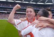 26 September 2004; Gareth Devlin, Tyrone, celebrates with manager Liam Doyle after victory over Kerry. All-Ireland Minor Football Championship Final, Kerry v Tyrone, Croke Park, Dublin. Picture credit; Brian Lawless / SPORTSFILE *** Local Caption *** Any photograph taken by SPORTSFILE during, or in connection with, the 2004 All-Ireland Minor Football Final which displays GAA logos or contains an image or part of an image of any GAA intellectual property, or, which contains images of a GAA player/players in their playing uniforms, may only be used for editorial and non-advertising purposes.  Use of photographs for advertising, as posters or for purchase separately is strictly prohibited unless prior written approval has been obtained from the Gaelic Athletic Association.