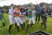 14 October 2013; Jockey Johnny Murtagh is carried towards a water trough by fellow jockeys after winning the Betfair Cash Out Flat & National Hunt Champion Jockeys Handicap on Goal at the Limerick Charity Race Day for the jockeys emergency fund. Limerick Racecourse, Greenmount Park, Co. Limerick. Picture credit: Diarmuid Greene / SPORTSFILE