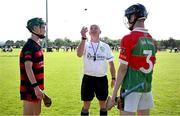 21 June 2025; Ballygunner captain Michael Moloney, left, and Ballinora captain Charlier Noonan, right, join referee Kevin Keogh for the coin toss before the Hurling Division 1 Final match between Ballygunner and Ballinora during the John West Féile na nGael Camogie and Hurling National Finals at Halo Tiles Wexford GAA Centre of Excellence in Ferns, Wexford. Photo by Shauna Clinton/Sportsfile