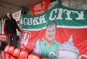 23 June 2025; Cork City volunteer Gerry Byrne prepares a flag in tribute to the late Cork City volunteer and founder of the Family Enclosure, John Kennedy, before the SSE Airtricity Men's Premier Division match between Cork City and Drogheda United at Turner's Cross in Cork. Photo by Thomas Flinkow/Sportsfile