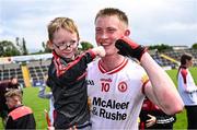 22 June 2025; Darren McAnespie of Tyrone celebrates with a young supporter after the Electric Ireland GAA Football All-Ireland Minor Championship semi-final match between Tyrone and Roscommon at Kingspan Breffni in Cavan. Photo by Seb Daly/Sportsfile