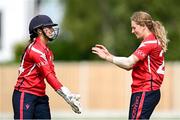 29 June 2025; Dragons bowler Alana Dalzell celebrates with teammate Amy Hunter after taking the wicket of Scorchers batter Bella Armstrong during the Evoke Super 20 Trophy match between Scorchers and Dragons at Railway Union Cricket Club in Dublin. Photo by Seb Daly/Sportsfile