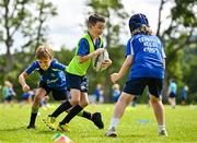 3 July 2025; James Tijs, centre, is tackled by Liam Wright, left, and Toby Kenny during a Bank of Ireland Leinster Rugby Summer Camp at Stillorgan Rathfarnham RFC in Dublin. Photo by Sam Barnes/Sportsfile