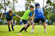 3 July 2025; James Tijs, centre, is tackled by Liam Wright, left, and Toby Kenny during a Bank of Ireland Leinster Rugby Summer Camp at Stillorgan Rathfarnham RFC in Dublin. Photo by Sam Barnes/Sportsfile