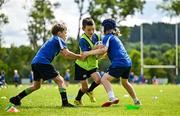 3 July 2025; James Tijs, centre, is tackled by Liam Wright, left, and Toby Kenny during a Bank of Ireland Leinster Rugby Summer Camp at Stillorgan Rathfarnham RFC in Dublin. Photo by Sam Barnes/Sportsfile