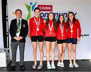 5 July 2025; President of Cairn Community Games Gerry McGuinness with members of thr Cork under-16 relay team that won gold from left Anna Murray, Claire Bradley, Cara Buckley and Doirenn Kerr all from Douglas during day one of the Cairn Community Games National Swimming, Quiz, Chess, Draughts and Gymnastics Finals 2025 at The Watershed in Kilkenny. Photo by Matt Browne/Sportsfile