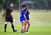 8 July 2025; Referee Eoin O'Neill looks on as Cavan's players Sinéad Carolan and Sadhbh Maguire take shelter under an umbrella during the LGFA U17 Player Development Day at Portlaoise GAA club in Portlaoise, Laois. Photo by Stephen Marken/Sportsfile