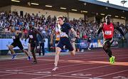 9 July 2025; Coby Hilton of USA, centre, finishes in first place ahead of Israel Olatunde of Ireland, right, who finished second, in the SuperValu Men's 100m Race 2 during the Cork City Sports meet at MTU Arena in Cork. Photo by Sam Barnes/Sportsfile