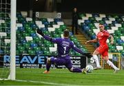 16 July 2025; Evan Caffrey of Shelbourne has a shot on goal despite the attention of Linfield goalkeeper Chris Johns during the UEFA Champions League First Qualifying Round second leg match between Linfield and Shelbourne at Clearer Twist National Football Stadium at Windsor Park in Belfast. Photo by Ben McShane/Sportsfile