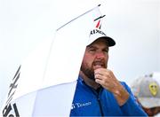 17 July 2025; Shane Lowry of Ireland uses an umbrella to shelter from the rain during day one of The 153rd Open Championship at Royal Portrush Golf Club in Portrush, Antrim. Photo by David Fitzgerald/Sportsfile