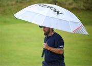 17 July 2025; Shane Lowry of Ireland uses a umbrella whilst walking on the seventh fairway during day one of The 153rd Open Championship at Royal Portrush Golf Club in Portrush, Antrim. Photo by David Fitzgerald/Sportsfile