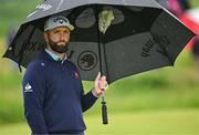 17 July 2025; Jon Rahm of Spain uses an umbrella to shelter from the rain on the 12th hole during day one of The 153rd Open Championship at Royal Portrush Golf Club in Portrush, Antrim. Photo by David Fitzgerald/Sportsfile