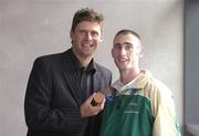 30 September 2004; Derek Malone, a member of the Ireland Paralympic team, and Bronze medallist in the T38 800m, shows his medal to ex-Republic of Ireland International Niall Quinn, on the teams arrival home from Athens. Dublin Airport, Dublin. Picture credit; Brian Lawless / SPORTSFILE