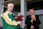30 September 2004; Conall McNamara, from Mayo, a member of the Ireland Paralympic team and silver medallist in the T13 400m, who will be starting a course at The Irish World Music Centre, University Limerick, plays the bagpipes as bagpipe player Michael Russell, who led the team through the airport, claps along, on their arrival home from Athens. Dublin Airport, Dublin. Picture credit; Brian Lawless / SPORTSFILE