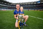 20 July 2025; Noel McGrath of Tipperary and his son Sam celebrate with the Liam MacCarthy cup after his side's victory in the GAA Hurling All-Ireland Senior Championship final match between Cork and Tipperary at Croke Park in Dublin. Photo by Stephen McCarthy/Sportsfile