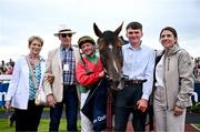 29 July 2025; Dunum with winning connections, from left, owners Mary and Maurice Burns, jockey Seamie Heffernan, groom Louis McGill and trainer Natalia Lupini after winning the COLM QUINN BMW Mile Handicap during day two of the Galway Races Summer Festival at Ballybrit Racecourse in Galway. Photo by David Fitzgerald/Sportsfile