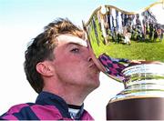 31 July 2025; Jockey Jack Kennedy celebrates by kissing the trophy after winning the Guinness Galway Hurdle Handicap on Ndaawi during day four of the Galway Races Summer Festival at Ballybrit Racecourse in Galway. Photo by Seb Daly/Sportsfile