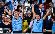 3 August 2025; Dublin players Nicole Owens, left, and Sinéad Goldrick lift the Brendan Martin cup after their side's victory in the TG4 All-Ireland Ladies Football Senior Championship final match between Dublin and Meath at Croke Park in Dublin. Photo by Seb Daly/Sportsfile